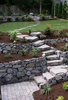 a garden with stone steps leading up to the grass