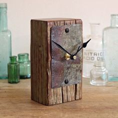 an old wooden clock sitting on top of a table next to some bottles and glassware