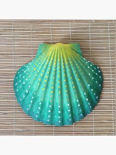 a green fan sitting on top of a bamboo mat