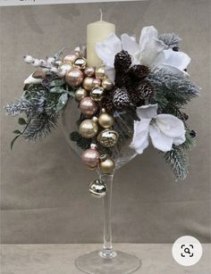 a wine glass filled with ornaments and a candle