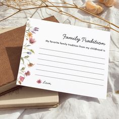 an open book sitting on top of a table next to some dried flowers and leaves