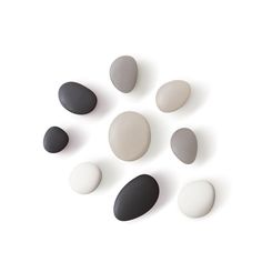 several black and white stones arranged in a circle on a white background, with shadows