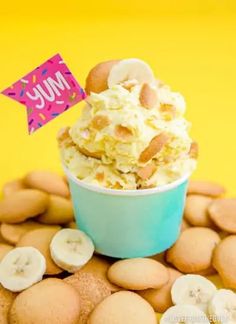 an ice cream sundae with banana slices and other desserts around it on a yellow background