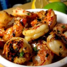 a white bowl filled with shrimp on top of a table