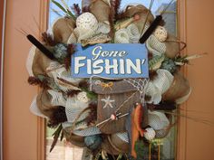 a fishing wreath with gone fishin written on the front door and other decorations around it