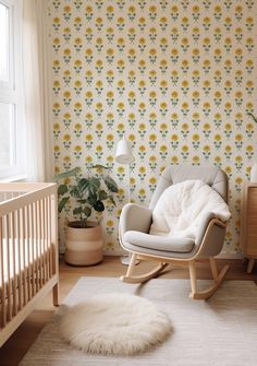 a baby's room with a rocking chair, crib and wallpaper that has yellow flowers on it