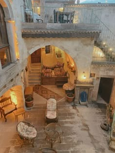 an aerial view of a living room with stone floors and stairs leading up to the second floor