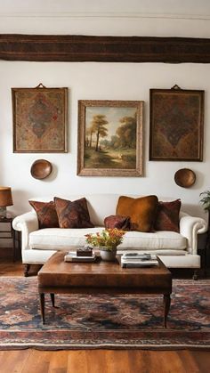 a living room filled with furniture and paintings on the wall above it's coffee table