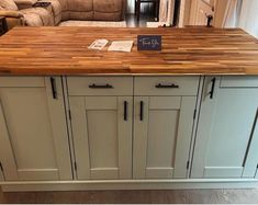 a kitchen island made out of wood and white cabinets