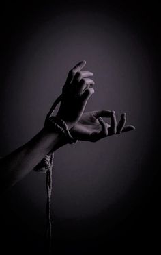 two hands reaching out to each other with one hand holding the other's string