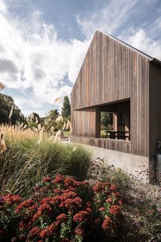 a wooden house surrounded by tall grass and flowers