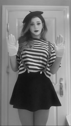 a woman in a sailor costume is standing by a door with her hands up to the side