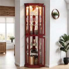 a tall red curio cabinet with wine glasses on it's front and bottom shelves