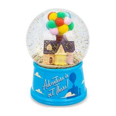 there is a snow globe with a house and balloons in it that says adventure is not there