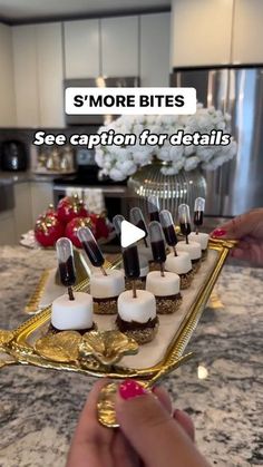 someone is holding a tray full of appetizers with candles on it and the text smore bites see caption for details