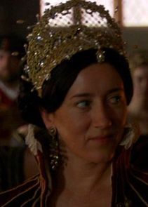 a woman with a crown on her head and people in the back ground behind her