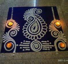 an intricately designed blue and white mat with candles on it in front of the floor