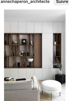 a living room filled with furniture and bookshelves next to a white couch in front of a window