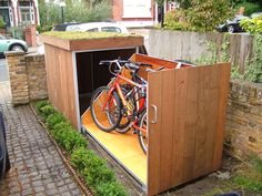 a bike is parked in the back of a wooden storage shed with grass growing on top