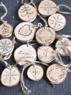 wood slice ornaments with writing on them are tied up to twine and placed on a table