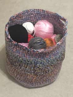 a knitted basket with yarn and knitting needles