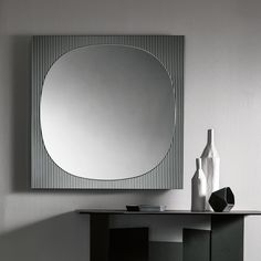 a mirror and vase on a table in a room