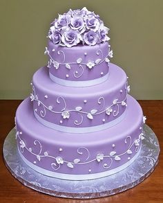 a purple wedding cake with white flowers on top