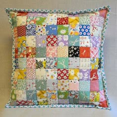 a multicolored patchwork pillow on a wall