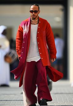 a man in red jacket and pants walking down the street