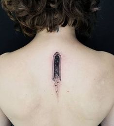 the back of a woman's neck with a knife tattoo on her left shoulder