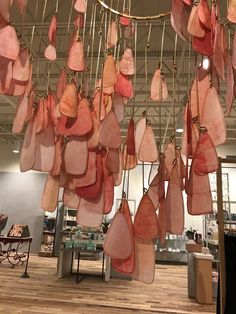 several pieces of meat hanging from the ceiling in a room with wooden floors and tables