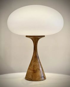 a wooden table lamp with a white light on top