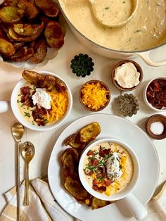 a table topped with plates of food next to a pot filled with soup and potatoes