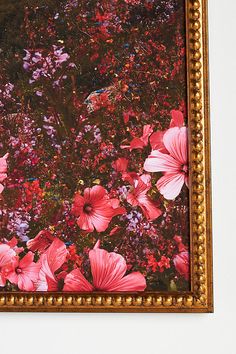 a painting hanging on the wall with flowers in it