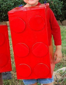 a young boy is holding two large red blocks