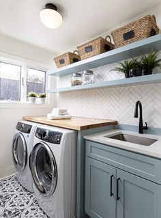 a washer and dryer in a small room with shelves above the washer