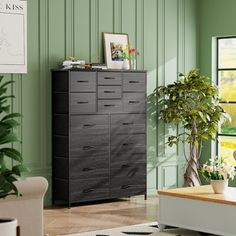 a living room with green walls and white rugs on the hardwood floor, along with a black dresser