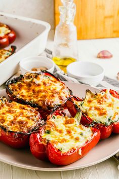 some stuffed peppers are on a plate with other food items in the backgroud