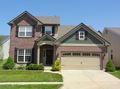 a large brick house with two garages in the front yard