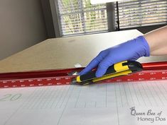 a person in blue gloves and rubber gloves is using a ruler to measure the length of a mattress