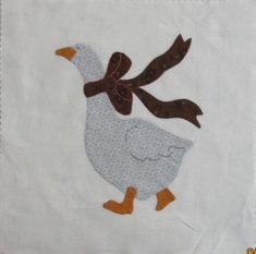 a white towel with an embroidered duck and two brown birds on it's back