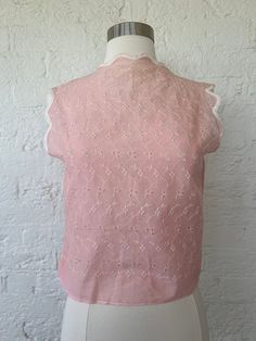 Vintage eyelet top with scalloped edges. Looks to be handmade. Feels like cotton. Can be worn with closure in front or back. Straight silhouette.  Flaws: discoloration at collar and underarms. Minor Stains throughout. The hem is uneven when snapped close.  Measurements: Bust: 16.5" Length: 19.5" Shoulder to shoulder: 14" xcvj42 Feminine Cotton Lace Top With Lace Trim, Summer Cotton Lace Top Blouse, Summer Cotton Lace Blouse, Fitted Cotton Lace Top With Broderie Anglaise, Spring Lace Top With Scalloped Edges, Lace Collar Top For Summer Daywear, Summer Lace Collar Top For Daywear, Summer Lace Top With Lace Collar, Summer Lace Top With Lace Collar For Daywear