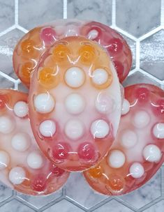 three gummy bears sitting next to each other on top of a marble countertop