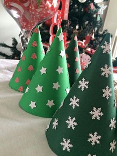 three green and white christmas trees sitting on top of a table