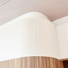 a clock on the side of a wall in a room with white walls and wood paneling