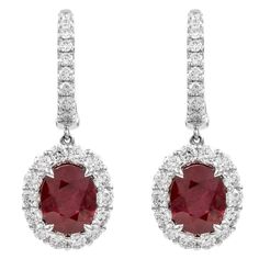 Sensational ruby and diamond drop earrings. Very clean rubies with superb vivid red color. Created by Alexander Beverly Hills. 6.81 carats total metal weight. 2 GIA certified oval Burma rubies, 4.91 carats total. Complimented by 46 round brilliant diamonds, 1.90 carats. Approximately F/G color and VS clarity. 18k white gold, 7.60 grams, 1.25in. Accommodated with an up to date digital appraisal by a GIA G.G. upon request, please contact us with any questions. Thank you. Item Number E4031 Rubies Earrings, Burmese Ruby, Gemstones Jewelry, Diamond Drops, Ruby Diamond, Burmese, Diamond Drop Earrings, Cluster Ring, Halo Diamond