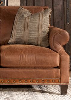 a brown leather chair with two pillows on it