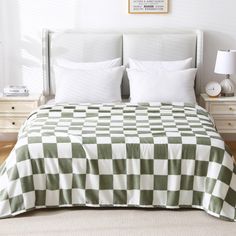 a bed with green and white checkered bedspread on top of it next to two nightstands