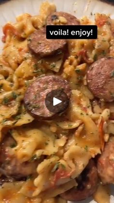 a white plate topped with pasta and sausage