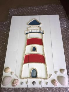 a cake made to look like a lighthouse with seashells on the bottom and sides